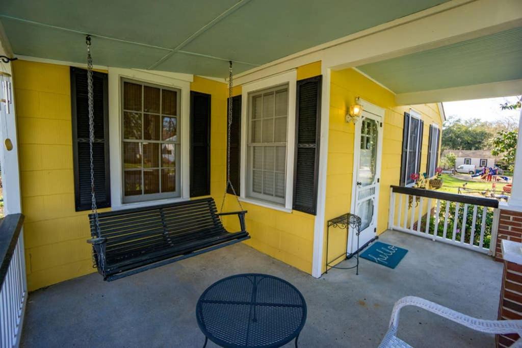 a yellow house with a bench on a porch at Graduations Welcome! Bayside Bungalow Close Proximity to Downtown Beaufort and Parris Island in Beaufort