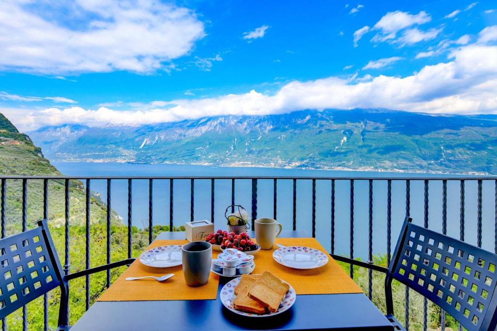 a table with bread and fruit on a balcony with a view at Melograno in Tignale