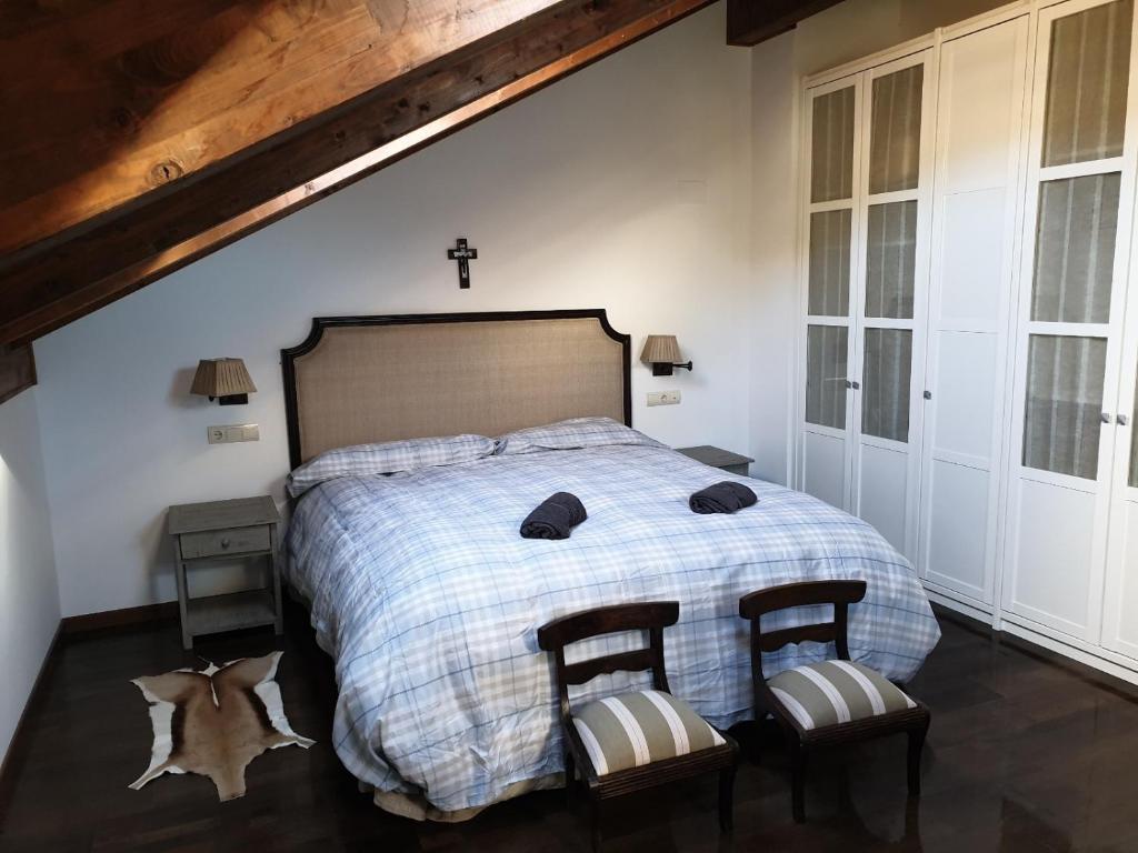 BadaguásにあるApartamento Santa Elena VUT-HU-20-093のベッドルーム1室(ベッド1台、椅子2脚、壁掛けクロス付)