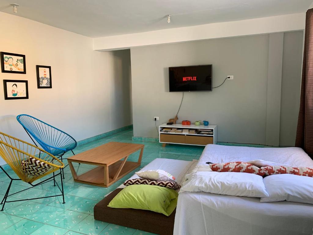 - un salon avec un canapé et une télévision dans l'établissement CoCo 2 Spacious Apartment Downtown with Garden, à Cozumel