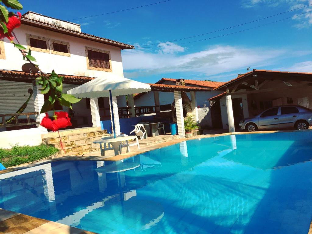 a large blue swimming pool in front of a house at Beach House Paracuru B&B - cama e café in Paracuru