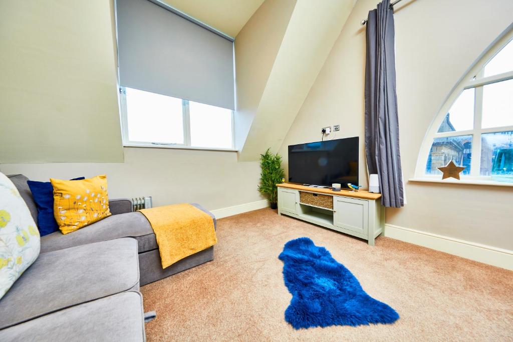 uma sala de estar com um sofá e uma televisão em Stunning Gems of Harrogate em Harrogate