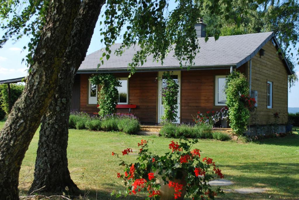 una casa con flores rojas delante de ella en Le Chalet à Bonnerue, en Houffalize