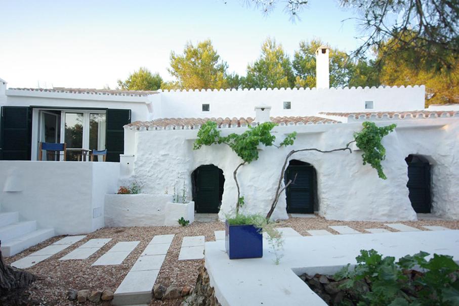 una casa blanca con un patio frente a ella en S'Olivera, en Alaior