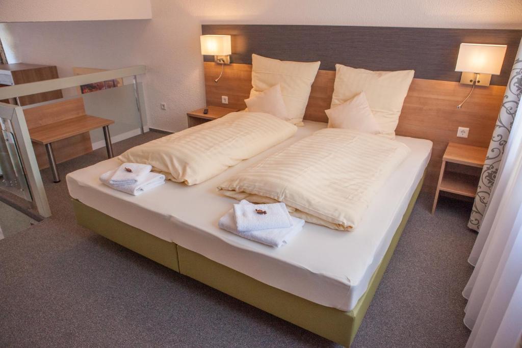 a bedroom with a large bed with towels on it at EulenNest in Laubach