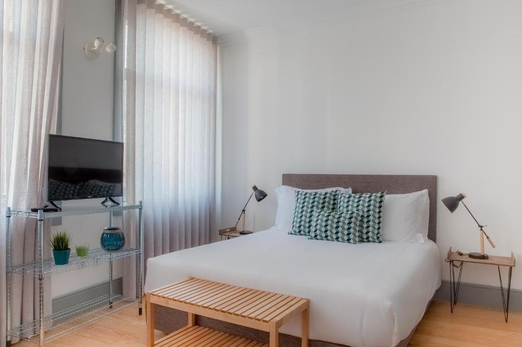 ポルトにあるCitybreak-apartments Coliseuのベッドルーム(大きな白いベッド1台、テーブル付)