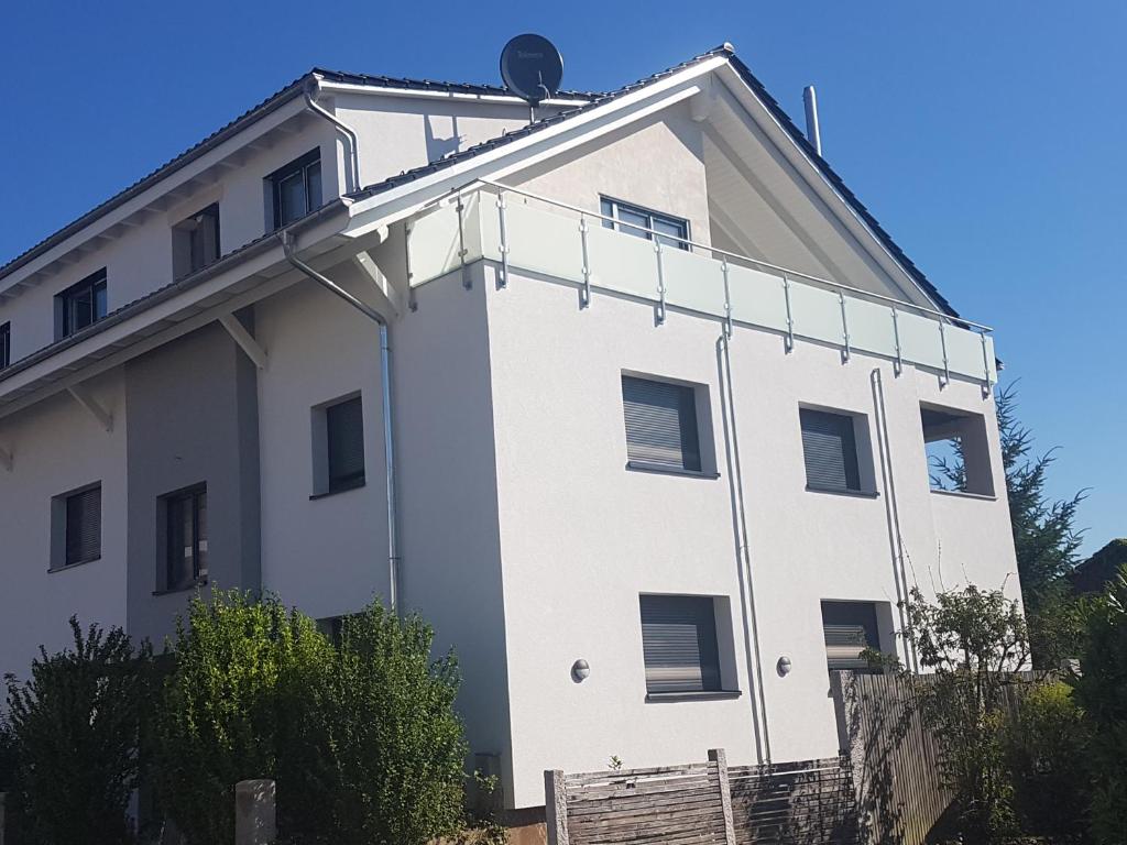 un bâtiment blanc avec un toit dans l'établissement Casa Colori Rheinfelden, à Herten