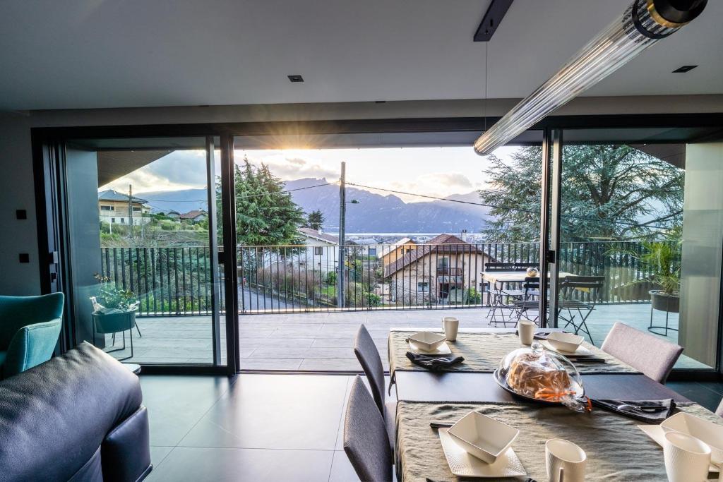 jadalnia ze stołem i dużym szklanym oknem w obiekcie Villa Casanova w Aix-les-Bains