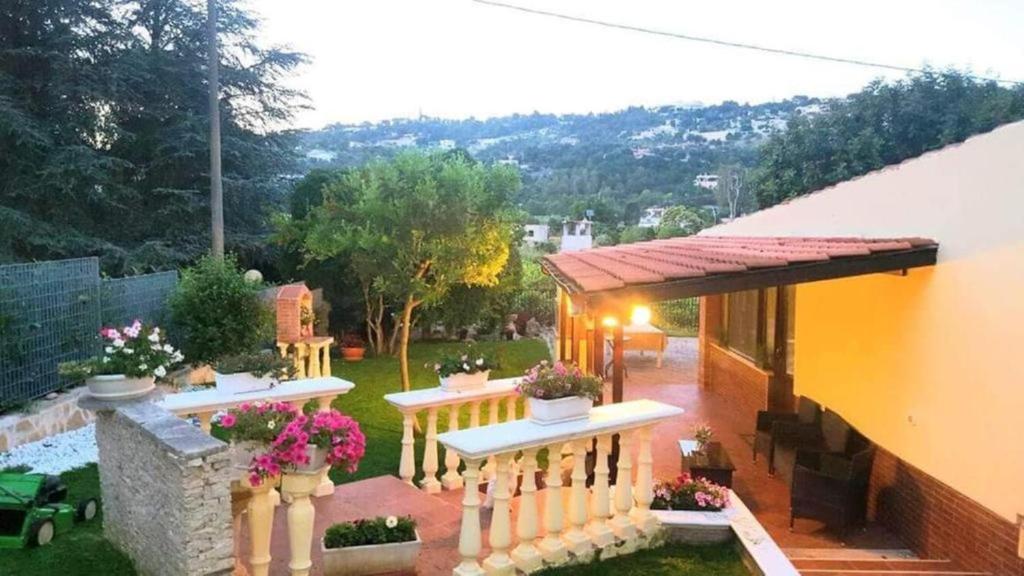ein Haus mit einem Zaun und Blumen im Hof in der Unterkunft Villa Barone in Selva di Fasano