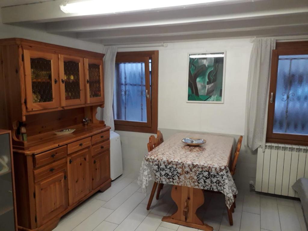 eine Küche mit einem Tisch und einem Waschbecken sowie einem Tisch mit Stühlen in der Unterkunft Casa Lorella in Chioggia