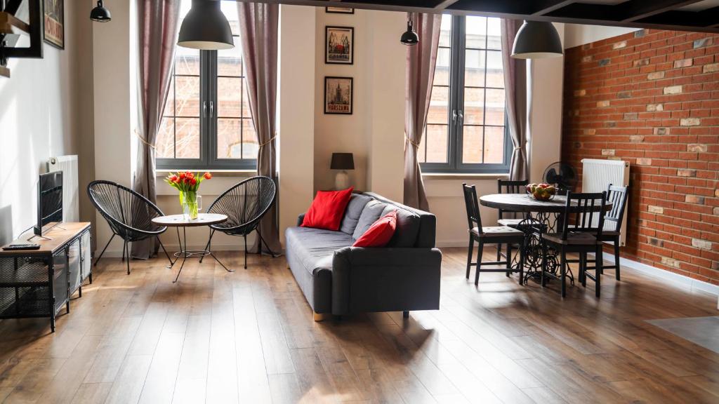 ein Wohnzimmer mit einem Sofa und einem Tisch mit Stühlen in der Unterkunft RedCity LOFT in Żyrardów