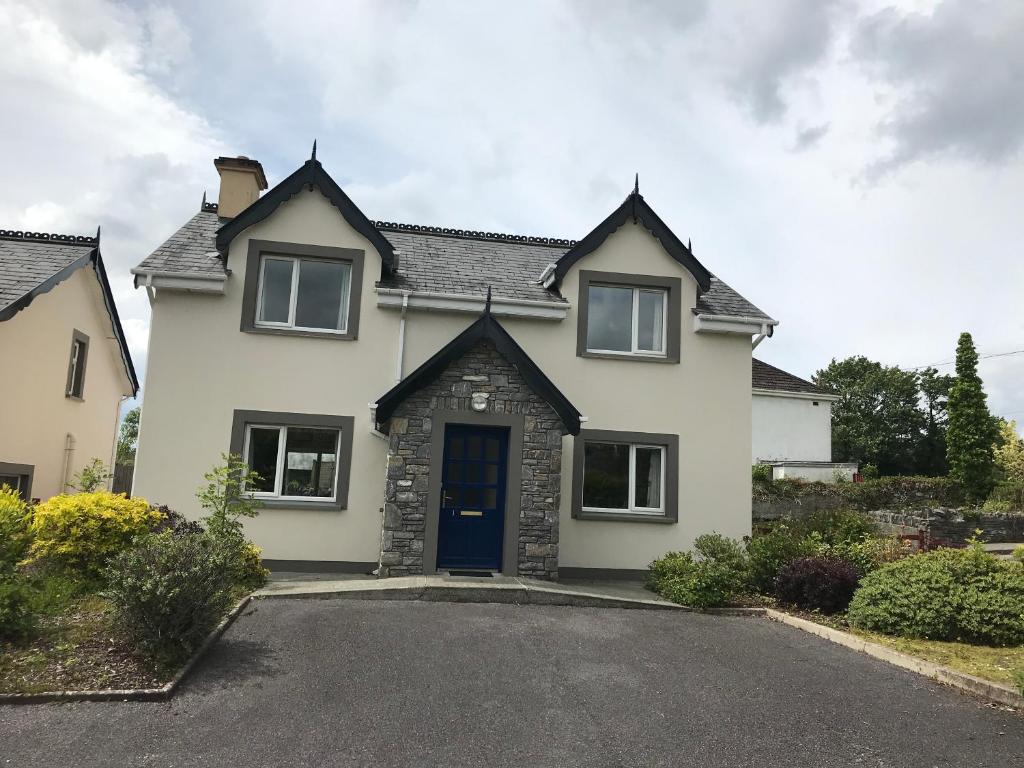 a white house with a blue door at 1 Sheen View in Kenmare