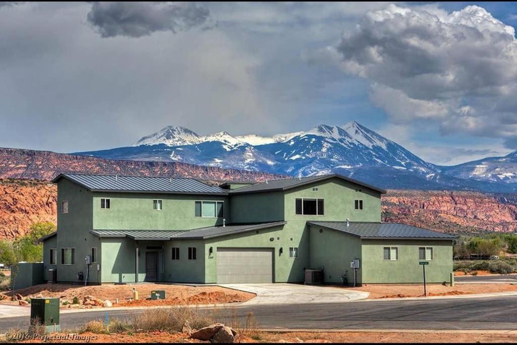 ein großes Haus mit Bergen im Hintergrund in der Unterkunft Exclusive Retreats Moab 3369 in Moab