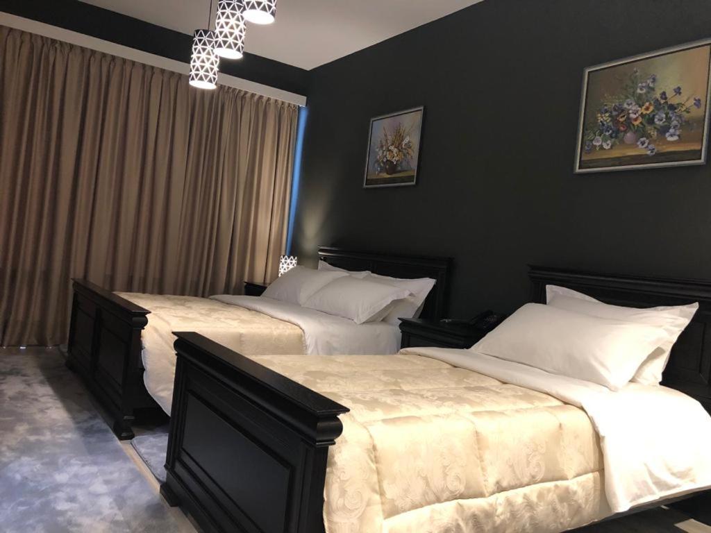 two beds in a bedroom with black walls at Dream's Hotel in Gjirokastër