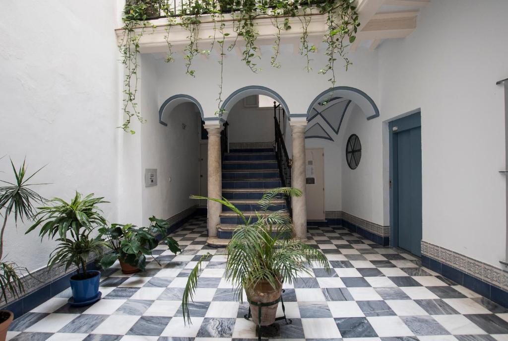 un pasillo con suelo a cuadros y escaleras en casa celia, en Cádiz