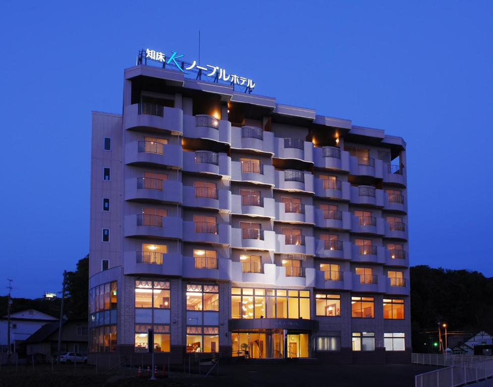 a hotel building with a sign on top of it at Shiretoko Noble Hotel in Shari