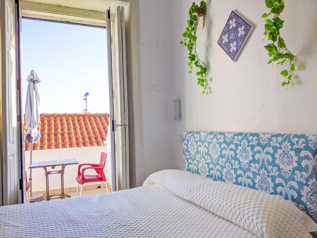 Schlafzimmer mit einem Bett, einem Tisch und einem Fenster in der Unterkunft Casa Londres in Estoril