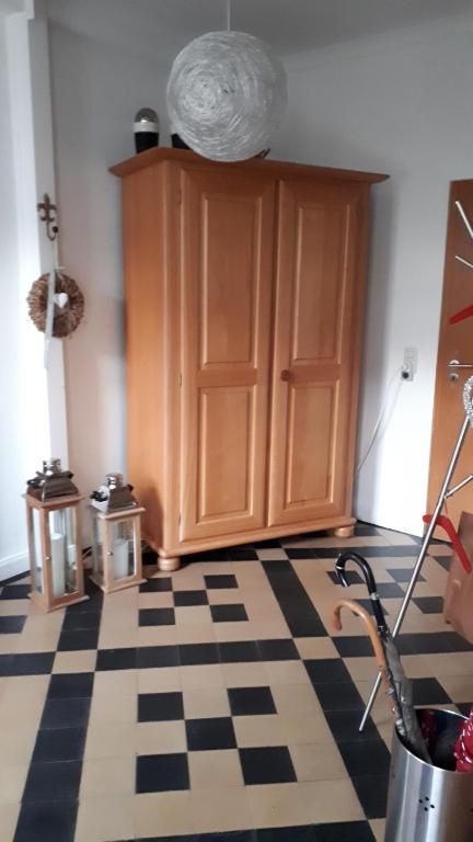 a kitchen with a wooden cabinet and a checkered floor at Am Diemelradweg in Warburg