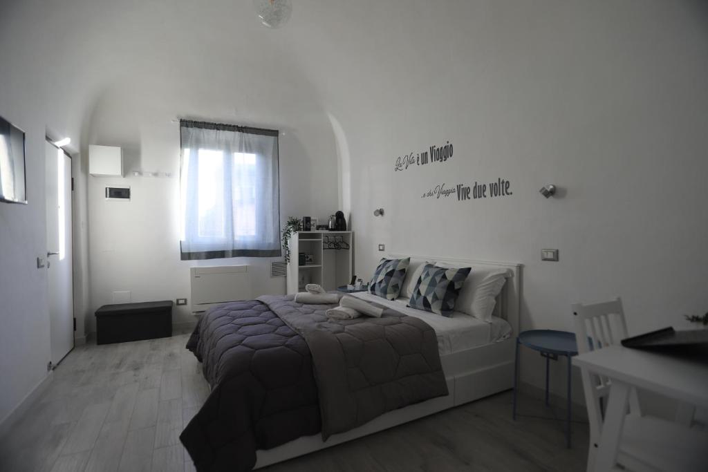 een witte slaapkamer met een bed en een raam bij N° 1 Flat Airport in Pisa