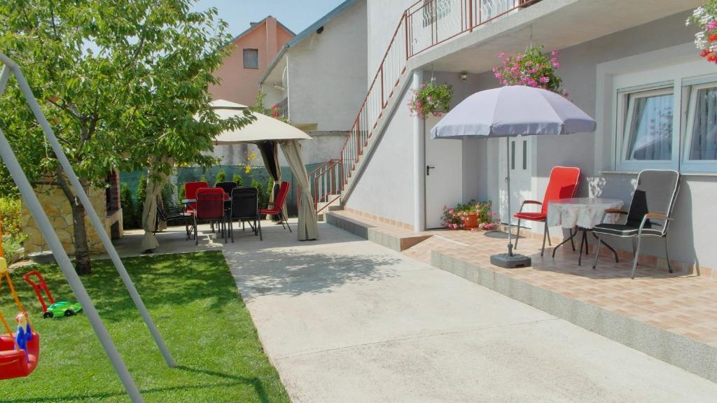 a patio with a table and chairs and an umbrella at Apartment Tina Gračac in Gračac