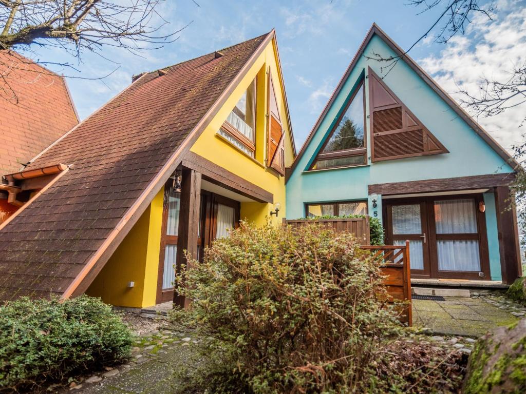 una casa gialla e blu con tetto marrone di Gîtes individuels à Kaysersberg a Kaysersberg