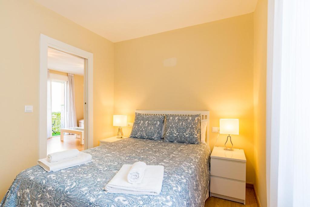sypialnia z łóżkiem i dwoma ręcznikami na nim w obiekcie Alferez II by ELE Apartments w Maladze