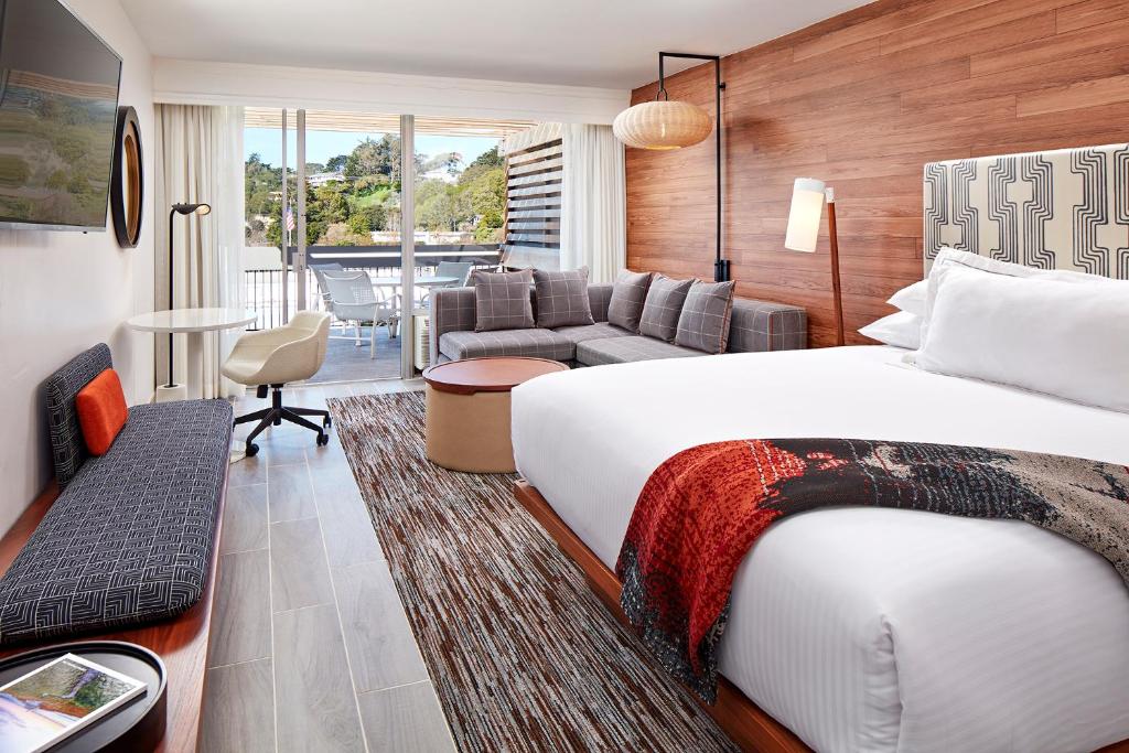 um quarto de hotel com uma cama e uma sala de estar em Carmel Mission Inn em Carmel