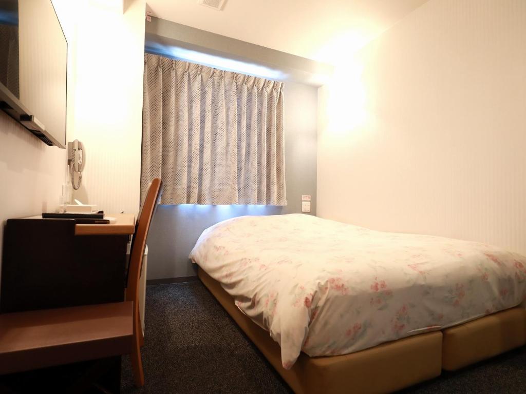 Postel nebo postele na pokoji v ubytování Toyama Town Hotel