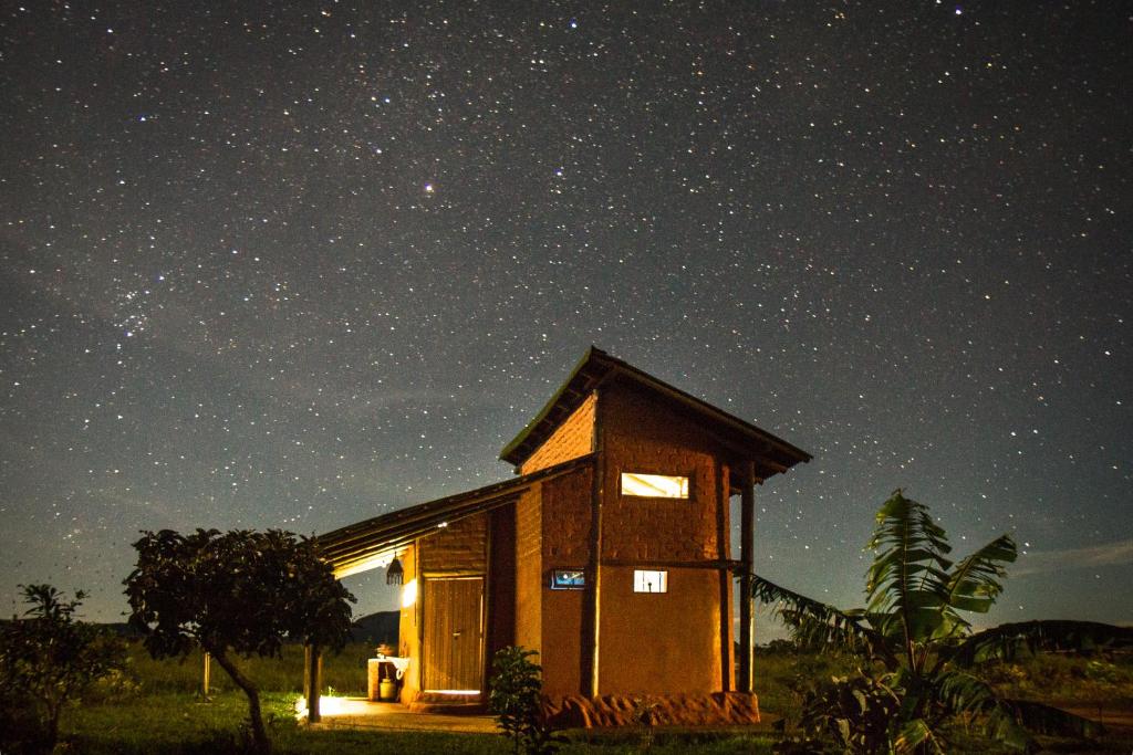 una pequeña casa bajo un cielo estrellado por la noche en Raizando Ecologia Humana en Alto Paraíso de Goiás