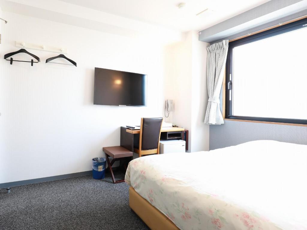 Tempat tidur dalam kamar di Toyama Town Hotel
