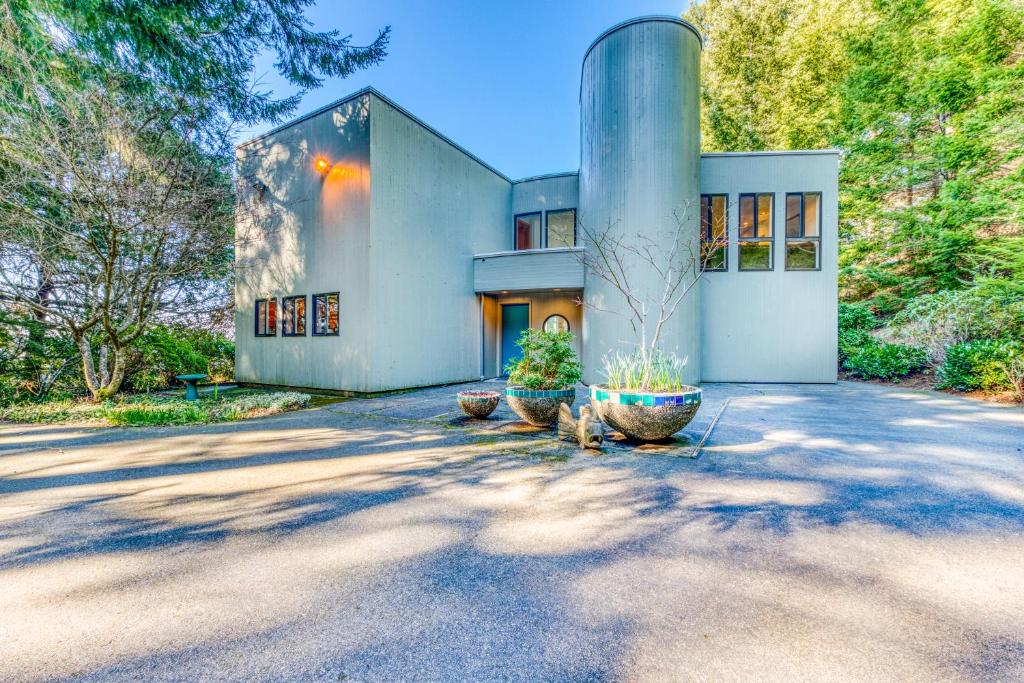 a house with two large pots in front of it at Forest Ridge Retreat in Coos Bay