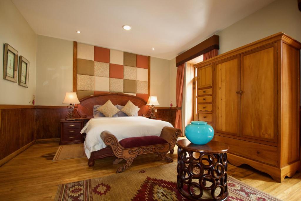 a bedroom with a bed and a blue vase on a table at Pepe's House Cuenca I Hotel & Boutique Hostel in Cuenca