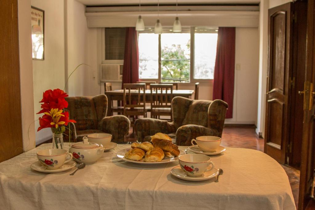 - une table avec des tasses de thé et des pâtisseries dans l'établissement Departamento céntrico en el corazón de la ciudad de Mendoza, à Mendoza