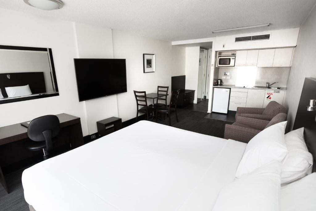 une chambre d'hôtel avec un lit et une cuisine dans l'établissement St Ives Apartments, à Hobart
