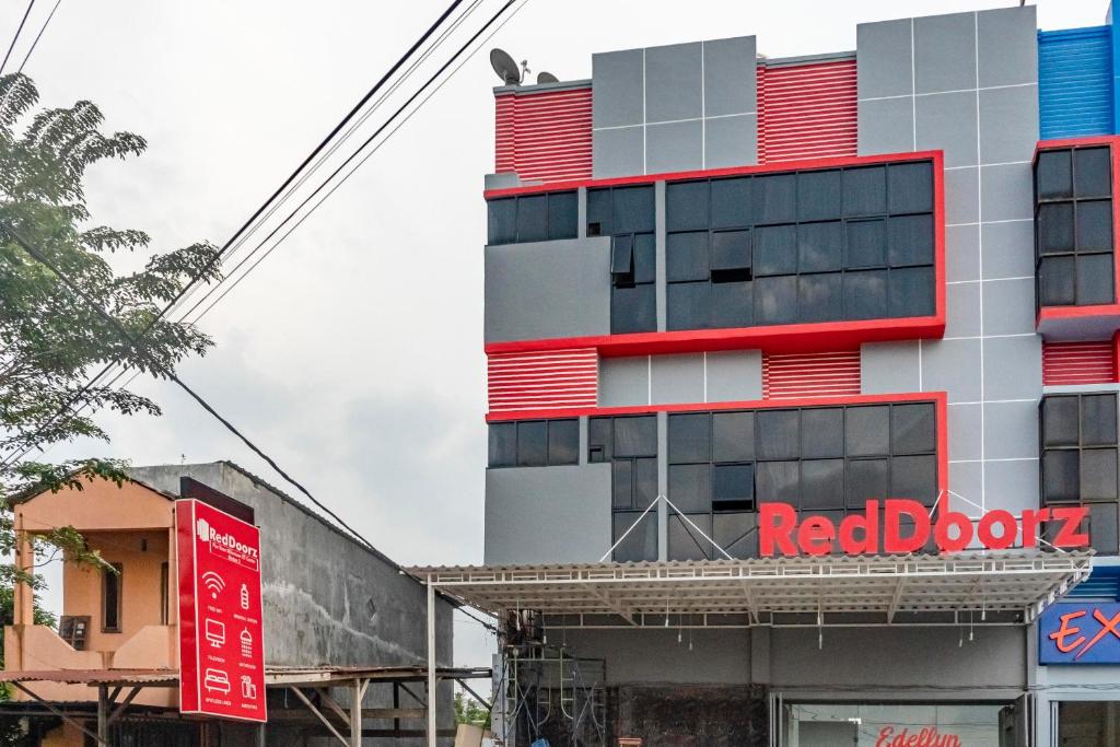 ein Gebäude mit einem roten Buchschild davor in der Unterkunft RedDoorz Plus near Millenium ICT Centre Medan 2 in Pulauberayan