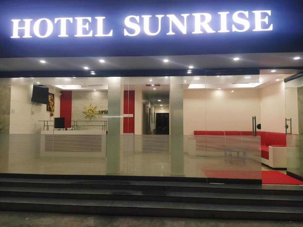 um sinal do nascer do sol do hotel na frente de um edifício em Hotel Sunrise em Kanyakumari