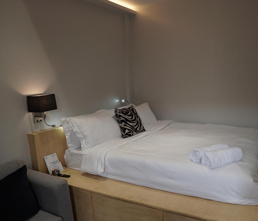 1 dormitorio con 1 cama blanca, escritorio y silla en Radlett Residences Hotel - Tuguegarao en Tuguegarao
