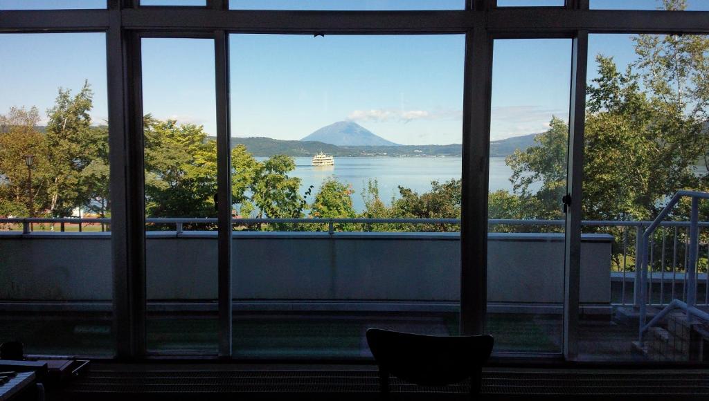 
a window with a view of a lake and mountains at Granvillage Toya Daiwa Ryokan Annex in Lake Toya
