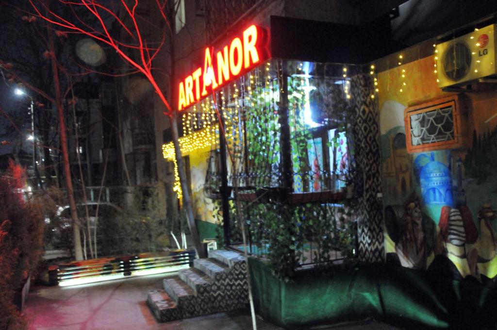 a building with a neon sign on the side of it at ARTANOR in Tashkent