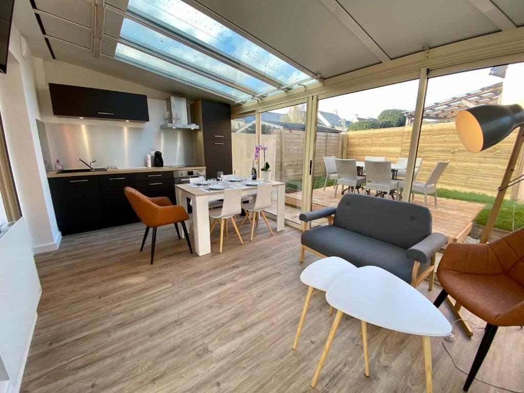 cocina y sala de estar con mesa y sillas en La Petite Maison De Bord De Mer, en Guidel