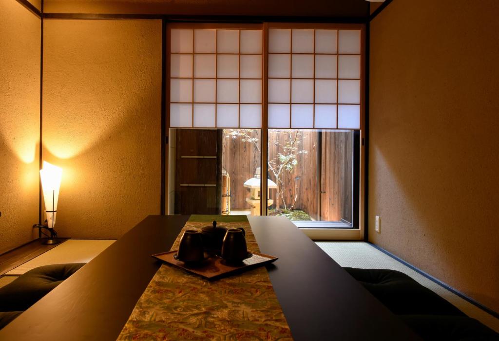 a room with a table and a large window at Rinn Premium Machiya Koki in Kyoto
