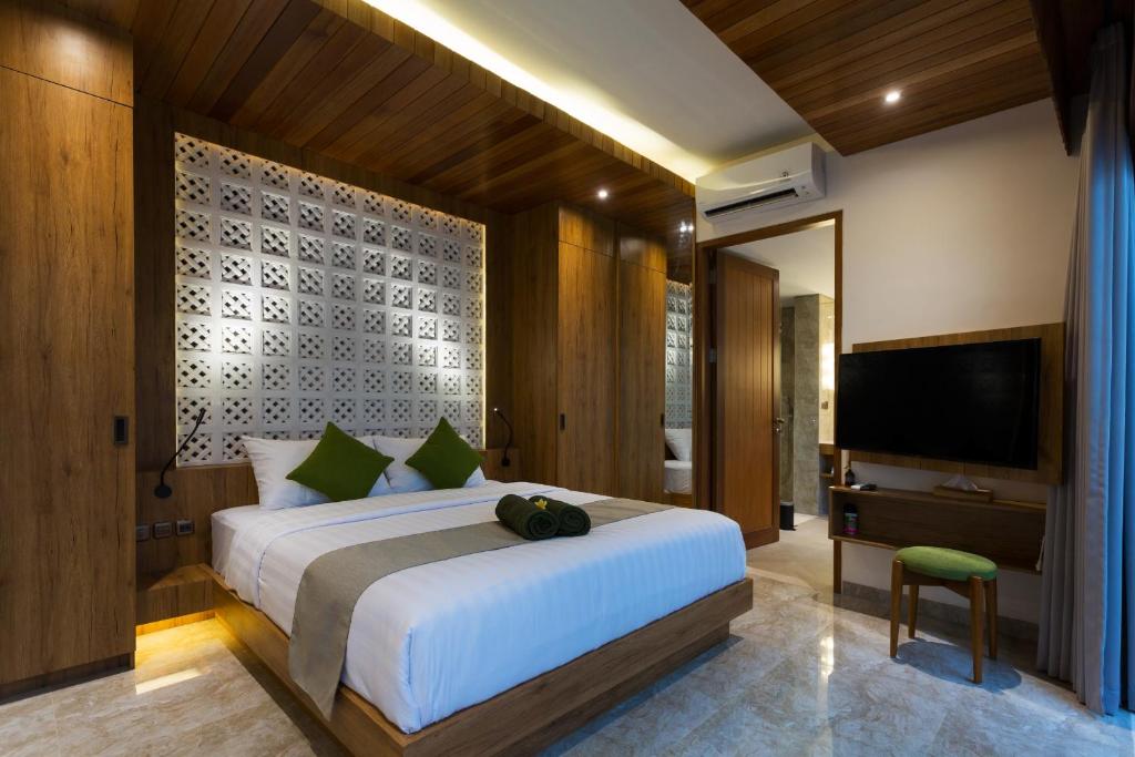 a bedroom with a large bed and a television at Danka Villa Sanur in Sanur