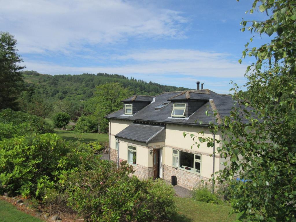 a house with a black roof on top of it at Glen Euchar House in Kilninver