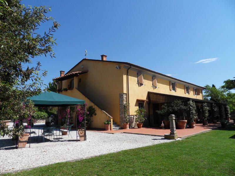 a building with a table and chairs in front of it at Agriturismo Spazzavento in Vecchiano