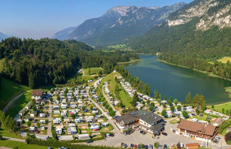 an aerial view of a parking lot next to a lake at Feriendorf Seeblick Toni in Kramsach