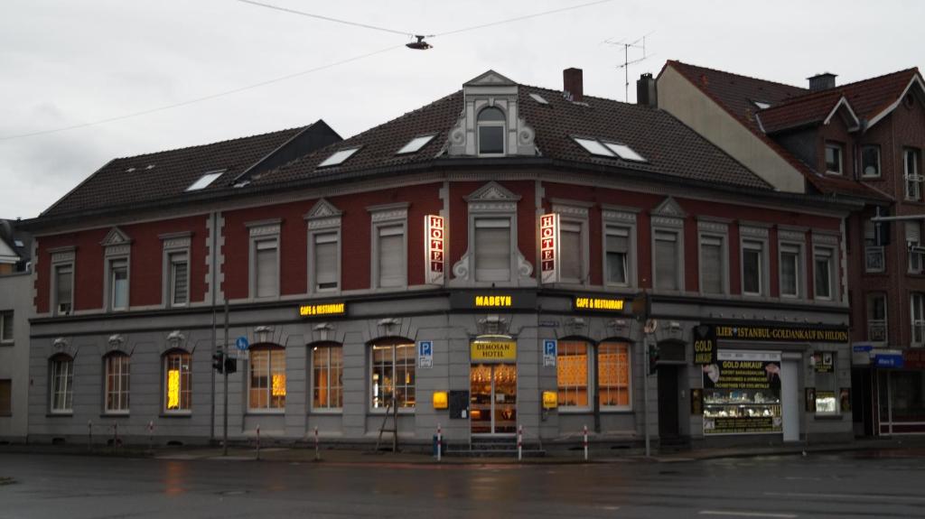 un gran edificio rojo en la esquina de una calle en Demosan Hotel Hilden, en Hilden