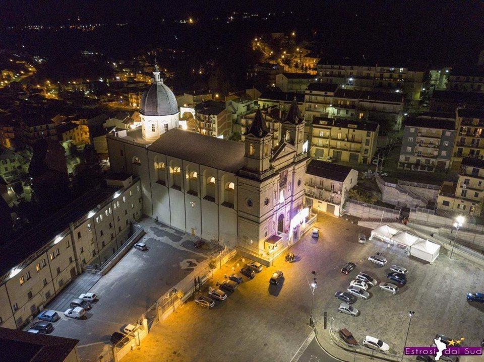 a large building with cars parked in a parking lot at night at B&B La Rosa dei Venti in Acri