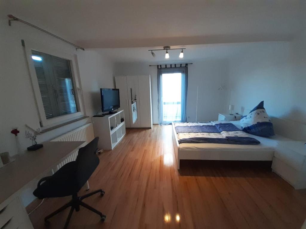 a living room with a bed and a desk and a desk at Heumaden hell und gemütlich eingerichtete 1-Zimmer Wohnung in Lederberg