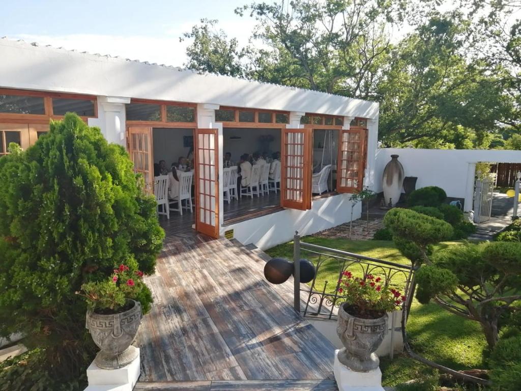a house with a deck with tables and chairs at De Witte Huis in Bethlehem