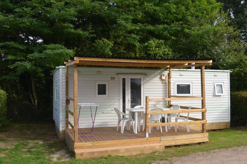 une cabine avec une table et des chaises sur une terrasse dans l'établissement Camping La Venise Du Bocage, à Nesmy